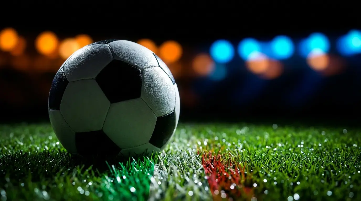 Pallone da calcio su campo illuminato con colori italiani